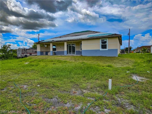 rear view of house featuring a lawn