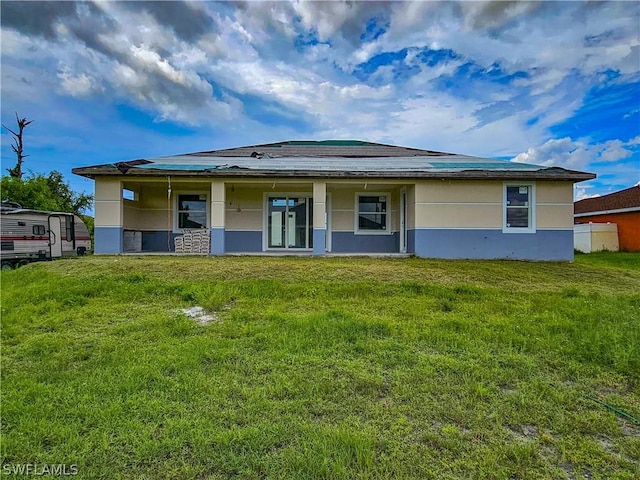 4111 22nd St SW, Lehigh Acres, FL 33976 - rear view of house featuring a yard, stucco siding, and covered porch