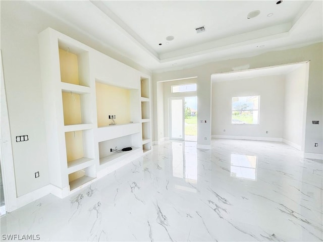 4111 22nd St SW, Lehigh Acres, FL 33976 - unfurnished living room with built in shelves, a tray ceiling, baseboards, and light marble finish floors