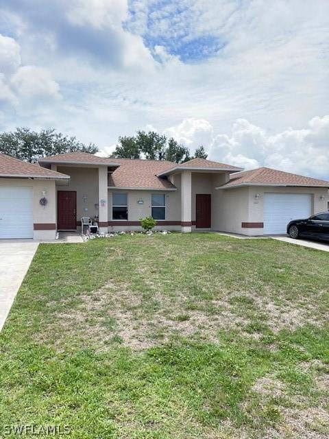 single story home with a garage and a front lawn