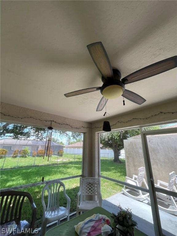 unfurnished sunroom with ceiling fan