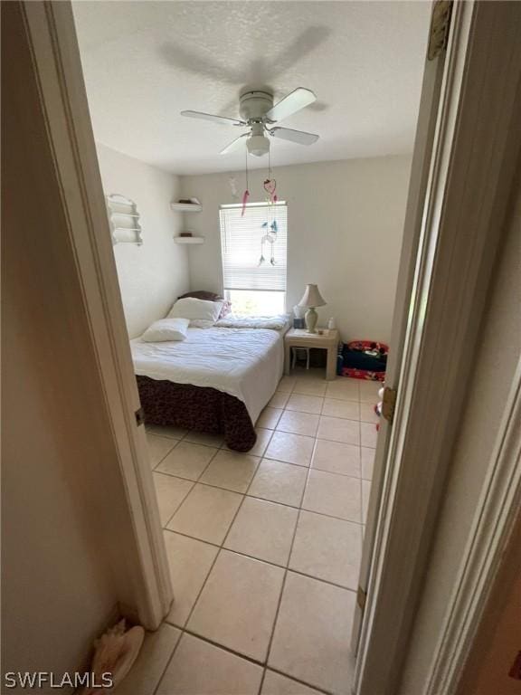 tiled bedroom featuring ceiling fan