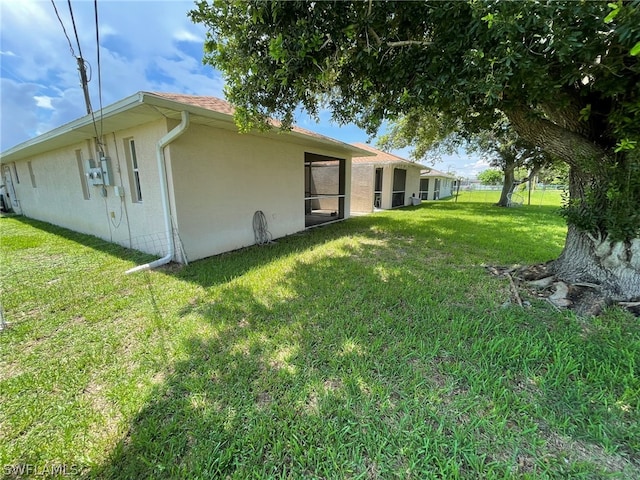 view of side of home with a yard