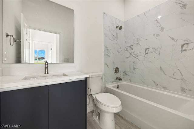 full bathroom with tiled shower / bath combo, vanity, wood-type flooring, and toilet