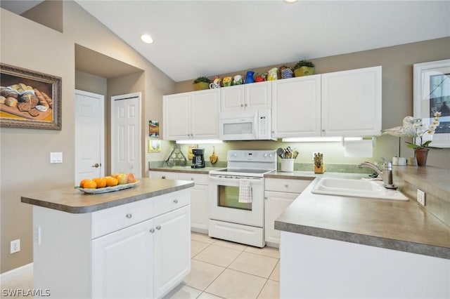 kitchen with sink, white appliances, a center island, white cabinets, and light tile patterned flooring