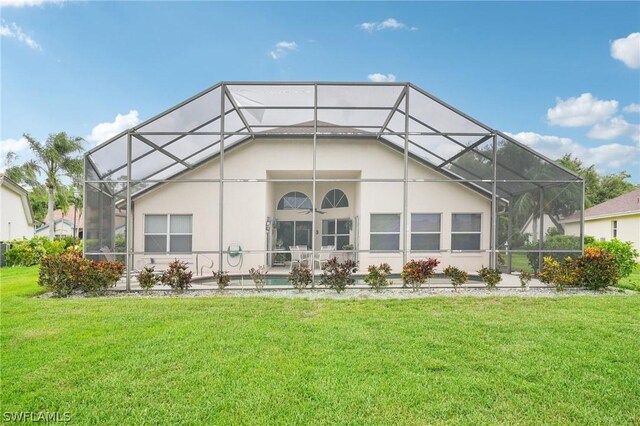 back of property featuring a lanai and a lawn