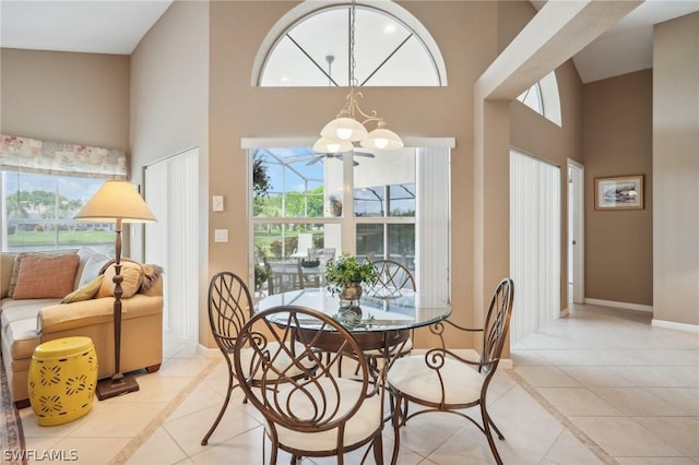 dining space with a high ceiling, a chandelier, and light tile patterned flooring