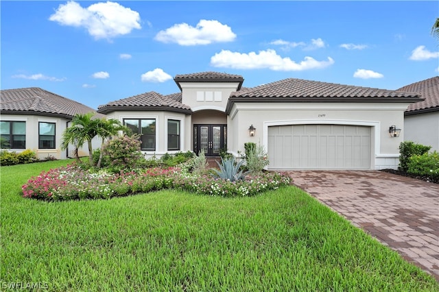 mediterranean / spanish home featuring a garage and a front lawn