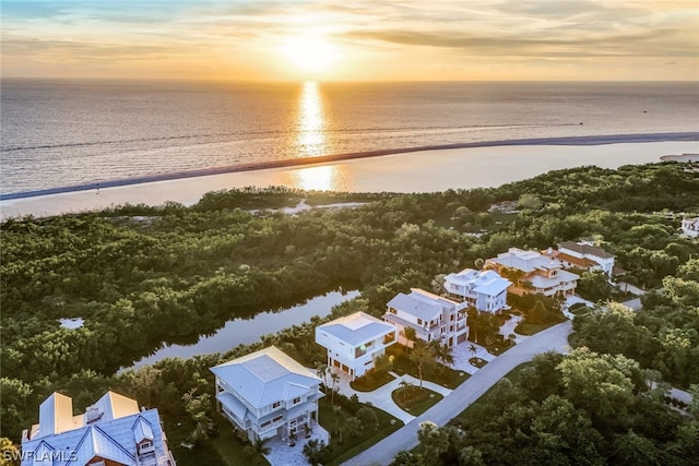 aerial view at dusk featuring a water view