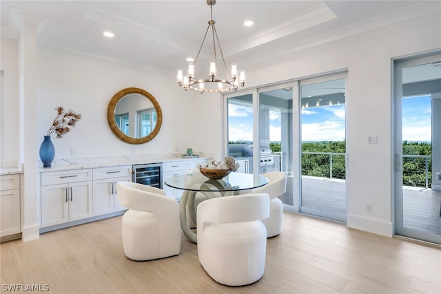 dining area with light wood finished floors, wine cooler, an inviting chandelier, and recessed lighting