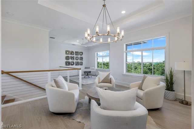 living area featuring baseboards, wood finished floors, a raised ceiling, and crown molding