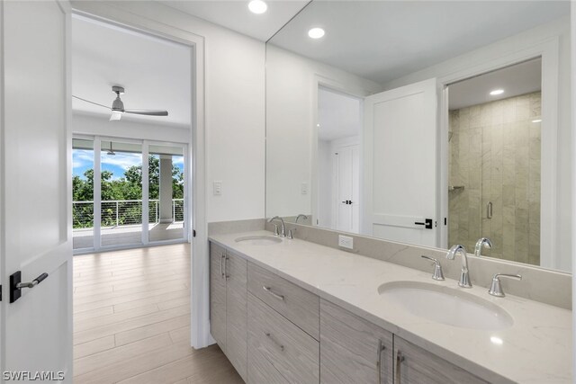 bathroom with hardwood / wood-style flooring, ceiling fan, walk in shower, and double vanity