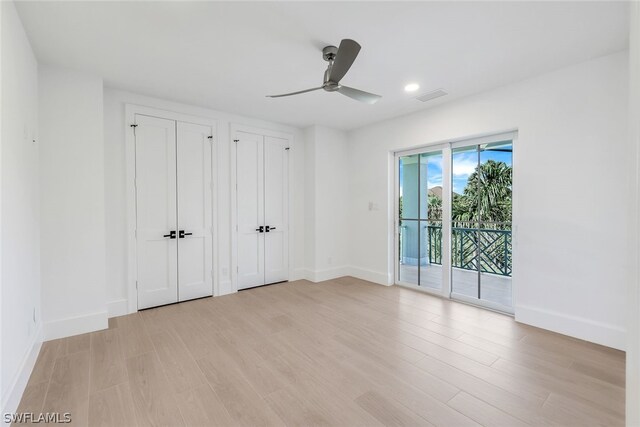 unfurnished bedroom featuring multiple closets, access to outside, ceiling fan, and light hardwood / wood-style floors