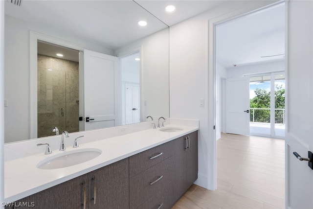 full bath featuring recessed lighting, a sink, a shower stall, and double vanity