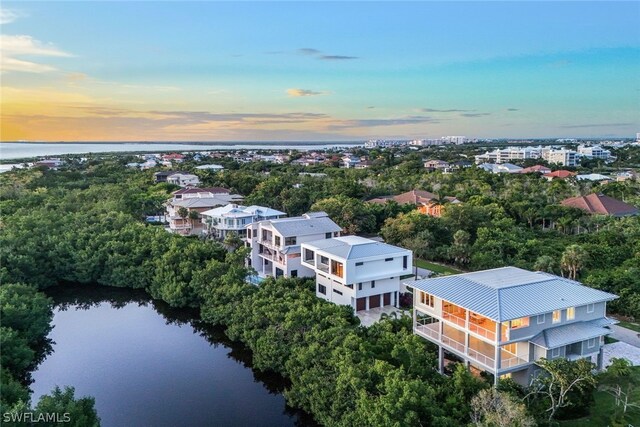 aerial view at dusk featuring a water view