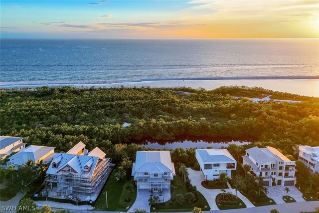 aerial view at dusk featuring a water view