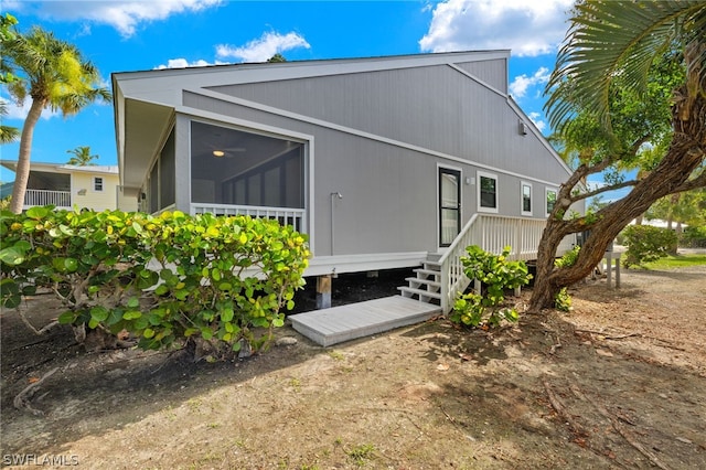 rear view of property featuring a sunroom