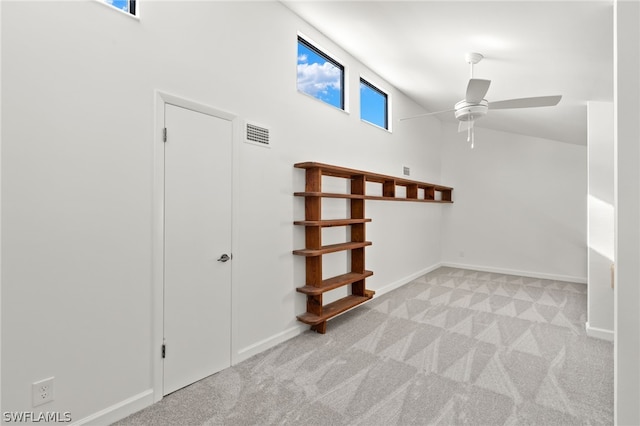 additional living space featuring ceiling fan and light colored carpet