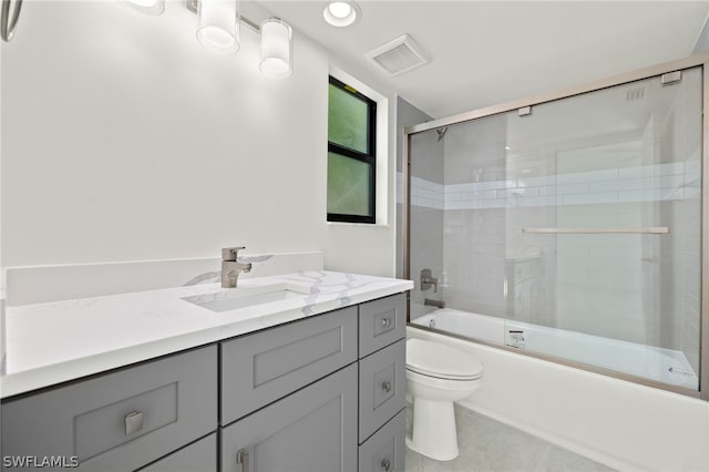 full bathroom with bath / shower combo with glass door, toilet, and vanity