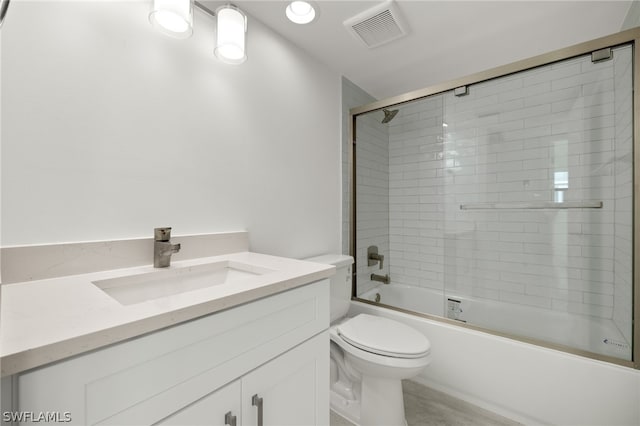 full bathroom featuring enclosed tub / shower combo, vanity, and toilet