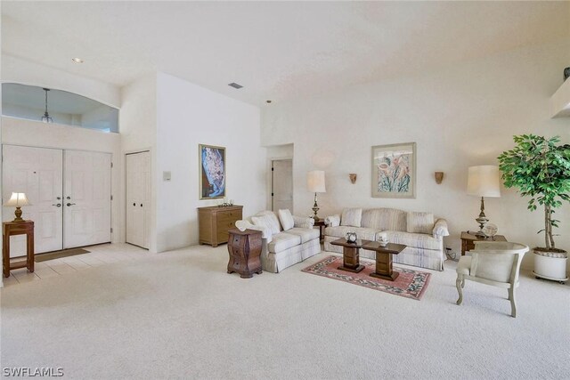 living room featuring light colored carpet and a high ceiling