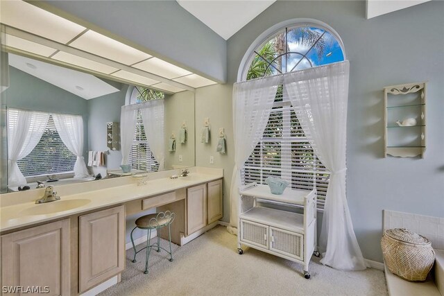 bathroom with vaulted ceiling and double sink vanity