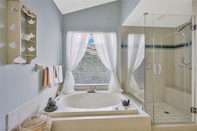 bathroom featuring independent shower and bath and lofted ceiling