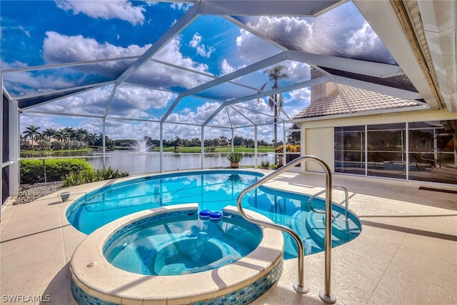 view of pool featuring a patio area, an in ground hot tub, a water view, and glass enclosure