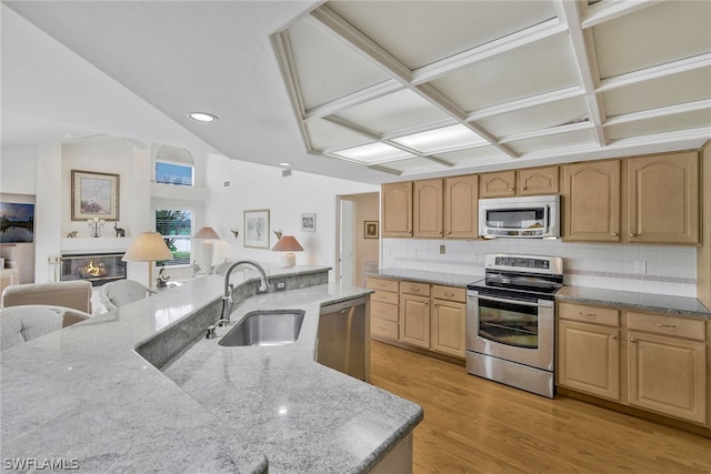 kitchen featuring decorative backsplash, sink, coffered ceiling, light hardwood / wood-style floors, and appliances with stainless steel finishes