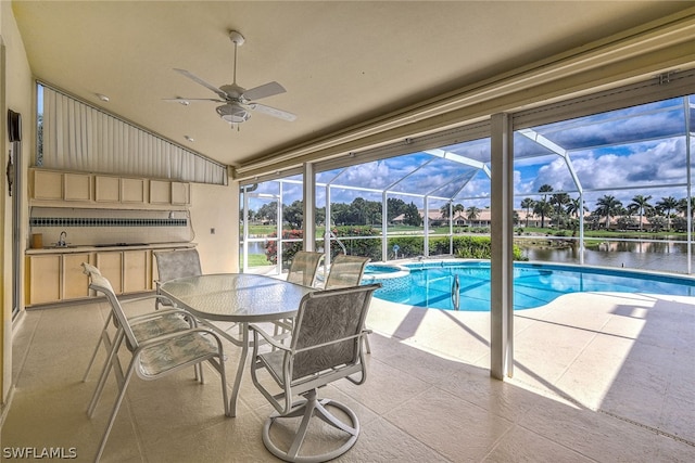 view of swimming pool with a water view, ceiling fan, glass enclosure, and a patio area