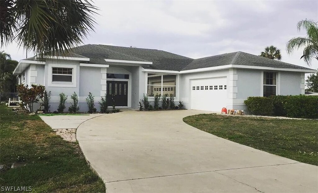 view of front of house featuring a garage and a front lawn