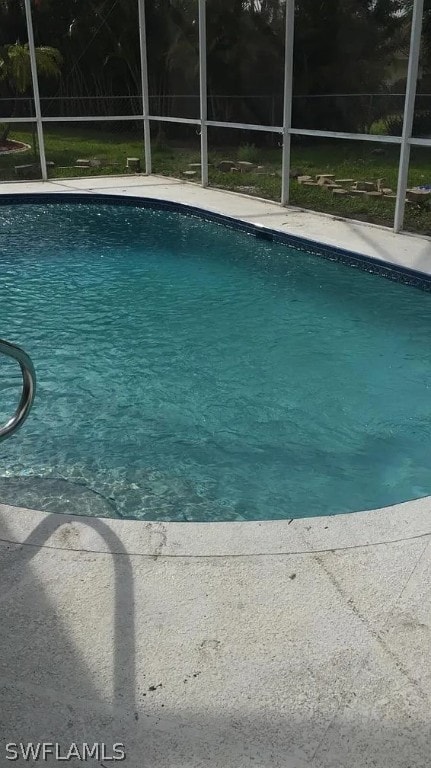 view of swimming pool with glass enclosure