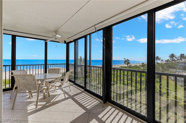 sunroom / solarium with ceiling fan, plenty of natural light, and a water view