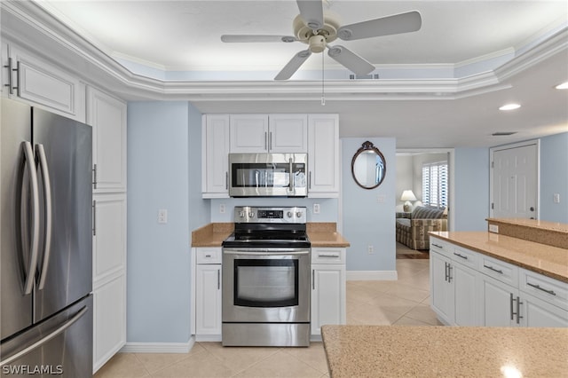 kitchen with white cabinets, ornamental molding, and stainless steel appliances