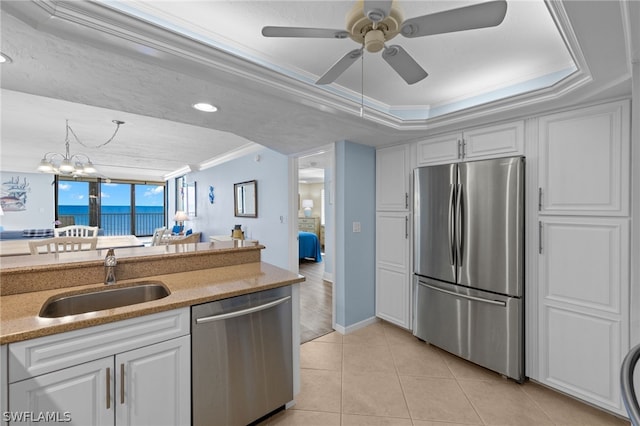 kitchen with a raised ceiling, white cabinetry, sink, and appliances with stainless steel finishes