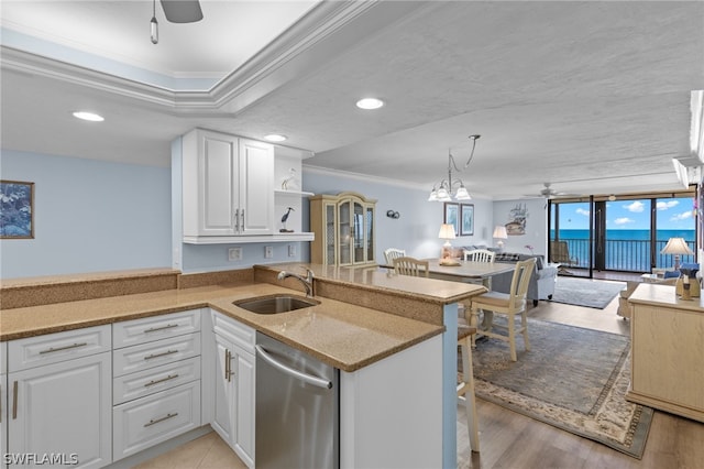 kitchen with dishwasher, crown molding, kitchen peninsula, sink, and white cabinetry