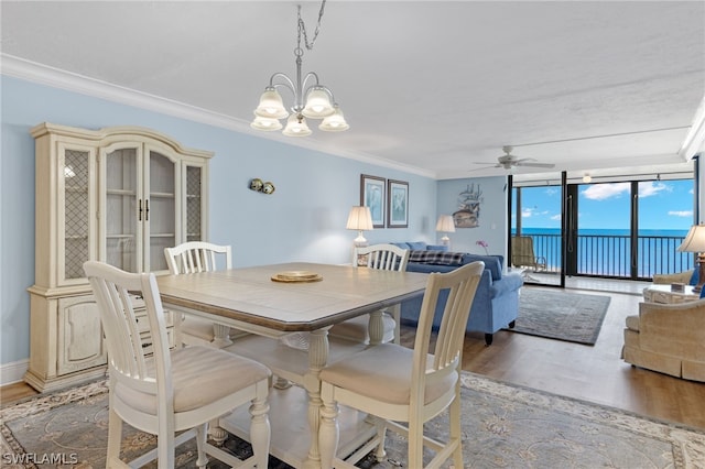 dining area featuring hardwood / wood-style floors, a water view, a wall of windows, and ornamental molding