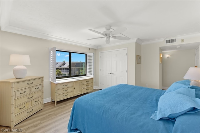 bedroom featuring ceiling fan, a closet, crown molding, and light wood-type flooring