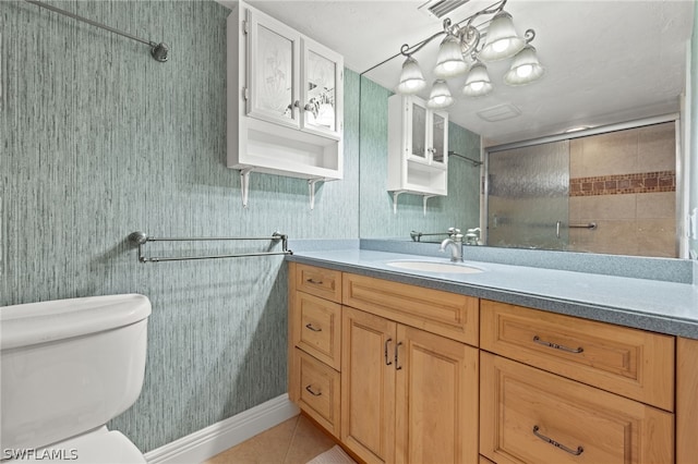 bathroom with tile patterned flooring, vanity, a shower with door, and toilet