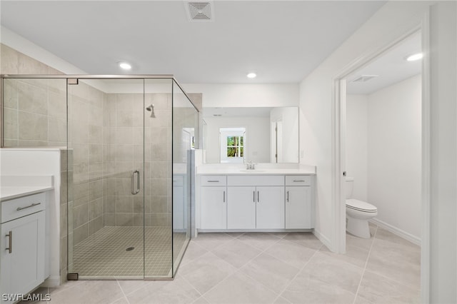 bathroom with tile patterned floors, vanity, toilet, and walk in shower