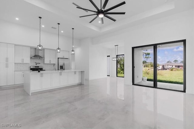 817 Jacaranda Pkwy E, Cape Coral, FL 33909 - kitchen featuring ceiling fan, light countertops, wall chimney exhaust hood, white cabinetry, and stainless steel appliances
