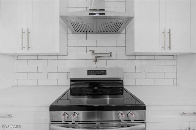 817 Jacaranda Pkwy E, Cape Coral, FL 33909 - kitchen with electric range, range hood, tasteful backsplash, light countertops, and white cabinetry