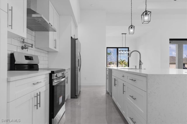 kitchen featuring white cabinets, stainless steel appliances, sink, and wall chimney range hood