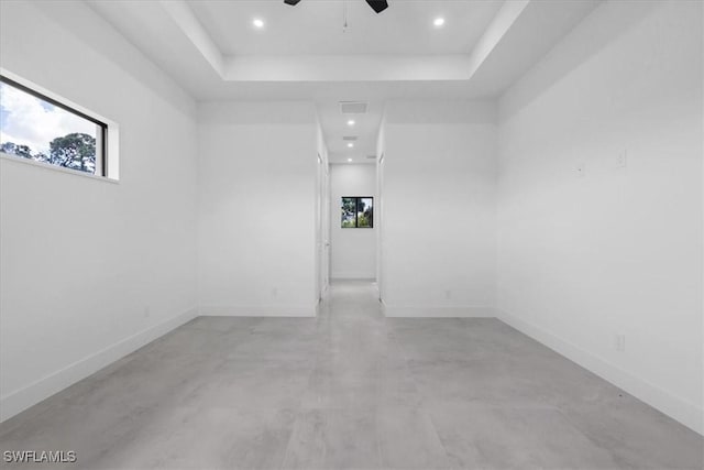 817 Jacaranda Pkwy E, Cape Coral, FL 33909 - empty room featuring concrete flooring, ceiling fan, a wealth of natural light, and a tray ceiling