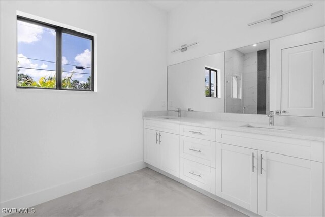 bathroom with a healthy amount of sunlight, walk in shower, vanity, and concrete floors