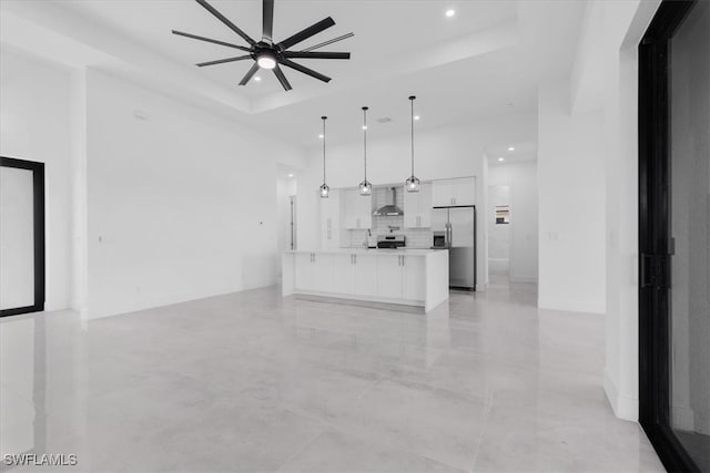 unfurnished living room with a tray ceiling and ceiling fan