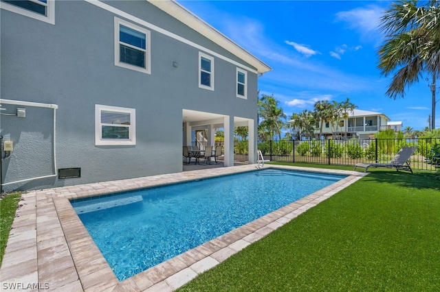 view of pool with a patio area and a yard