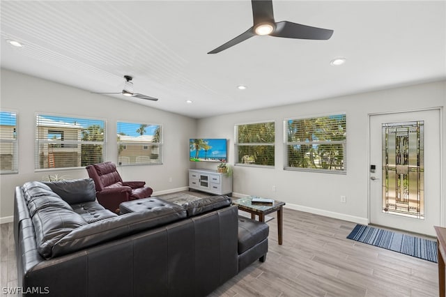 living room with plenty of natural light, vaulted ceiling, and light hardwood / wood-style flooring