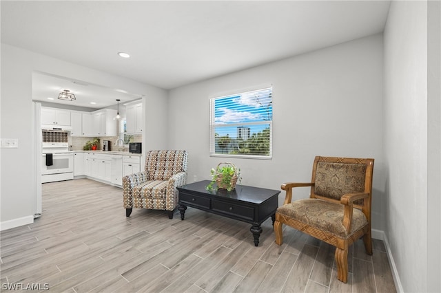 living area featuring light wood-type flooring and sink