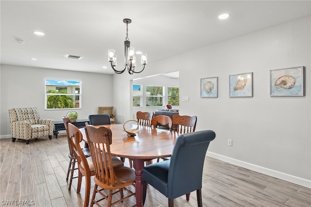 dining space featuring a chandelier, wood-type flooring, and a healthy amount of sunlight